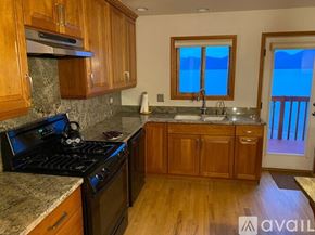 Polson house for rent - A kitchen with wooden cabinets and a black stove top.