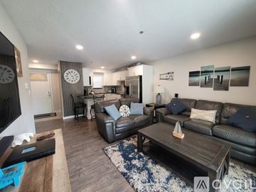 Polson apartment for rent - A living room with a black leather couch and a wooden coffee table.