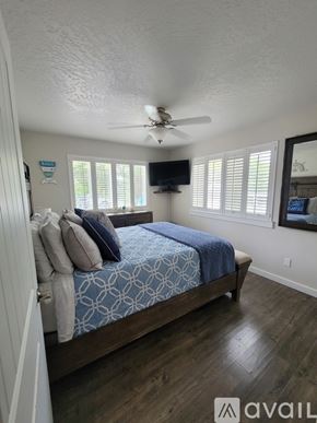 Polson apartment for rent - A bedroom with a bed, ceiling fan, and a window with blinds.