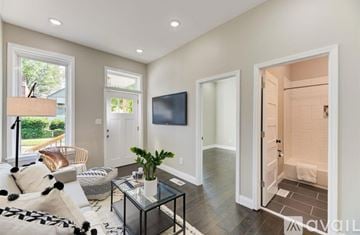 St. Louis house for rent - A living room with a glass coffee table and a flat screen TV on the wall.
