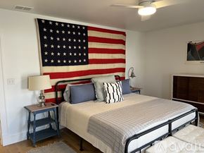 St. Joseph house for rent - A bedroom with a large American flag on the wall.