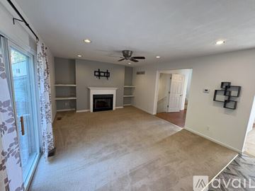 St. Louis house for rent - A living room with a grey couch and a fan on the ceiling.