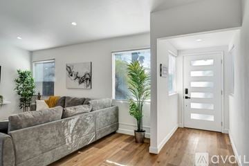Los Angeles house for rent - A living room with a grey couch and a white door.