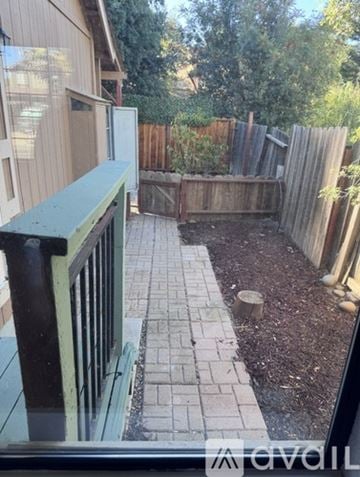 Antioch house for rent - A backyard with a wooden fence and a brick walkway.