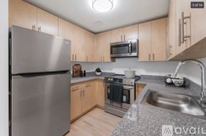 Peekskill apartment for rent - A kitchen with a stainless steel refrigerator, microwave, oven, and sink.