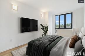 Peekskill apartment for rent - A bedroom with a large bed and a flat screen TV mounted on the wall.