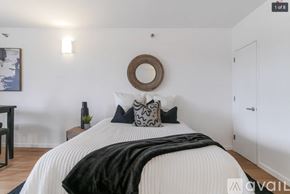 Peekskill apartment for rent - A bedroom with a white bed and a black and white pillow.