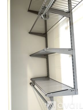 Philadelphia apartment for rent - A metal shelving unit with three shelves is mounted on a white wall.