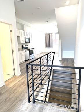 Philadelphia apartment for rent - A staircase with a metal railing leads to a brightly lit room.