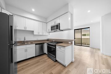 Los Angeles apartment for rent - A modern kitchen with white cabinets and wooden flooring.