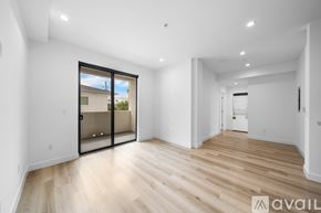 Los Angeles apartment for rent - A spacious room with wooden flooring and a sliding glass door leading to a balcony.