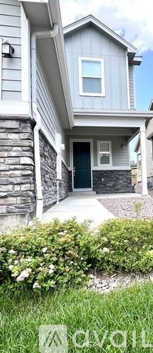 Colorado Springs townhouse for rent - A house with a grey facade and a green lawn in front.