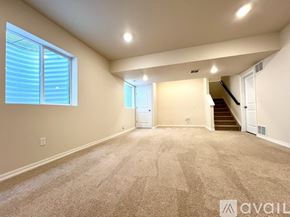 Colorado Springs townhouse for rent - A spacious room with carpeted floor, a staircase, and a window with blinds.