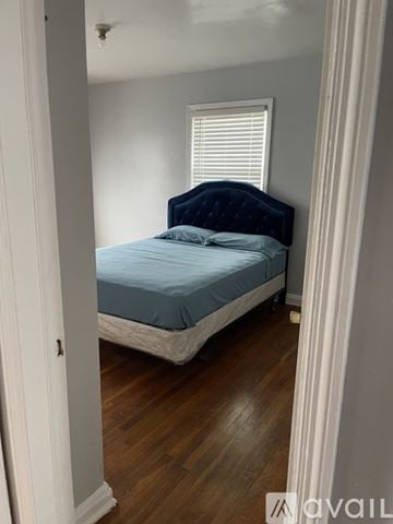 Baltimore house for rent - A bedroom with a bed and a window.