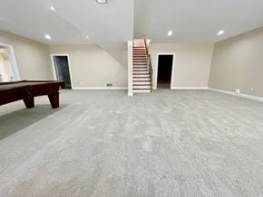 Louisville house for rent - A spacious room with a billiard table and a staircase.