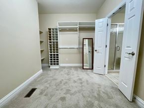 Louisville house for rent - A bedroom with a white door and a mirror on the wall.