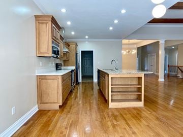 Louisville house for rent - A kitchen with wooden cabinets and a marble countertop.