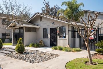 Manteca apartment for rent - A building with a white facade and a black gate.