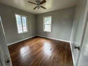 Provo house for rent - A room with wooden floors and a ceiling fan.