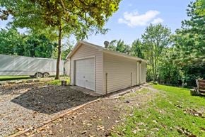 Jacksonville house for rent - A small house with a garage is surrounded by trees and has a gravel area in front.