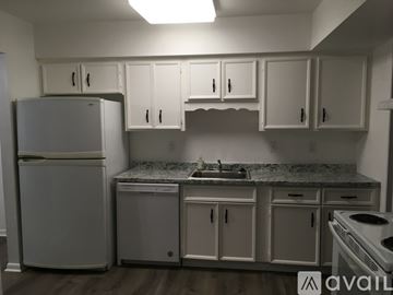 Virginia Beach house for rent - A kitchen with white cabinets and appliances.
