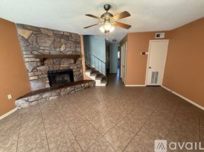Harvey townhouse for rent - A room with a fireplace and a staircase.