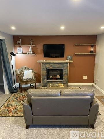 Colorado Springs apartment for rent - A grey couch is in front of a fireplace in a living room.