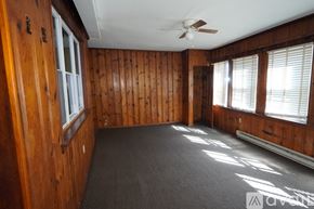 Baltimore apartment for rent - A room with wooden walls and a ceiling fan.
