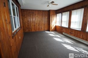 Baltimore apartment for rent - A room with wooden walls and a ceiling fan.