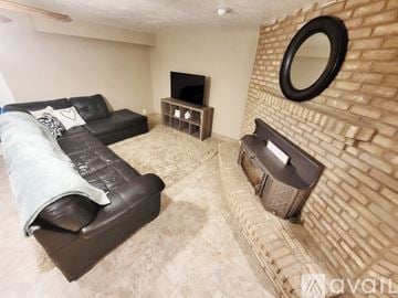 Idaho Falls apartment for rent - A living room with a black couch and a brick wall.
