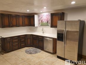 Idaho Falls apartment for rent - A kitchen with wooden cabinets and a stainless steel refrigerator.