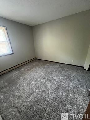 North Mankato apartment for rent - A room with a grey carpet and a window with blinds.