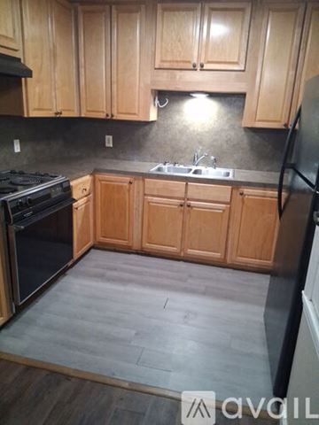 Bastrop apartment for rent - A kitchen with wooden cabinets and a black countertop.
