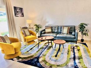 Palm Desert house for rent - A living room with a blue couch, yellow chairs, and a rug.