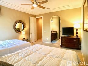 La Quinta house for rent - A bedroom with a large bed and a ceiling fan.
