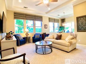 La Quinta house for rent - A living room with a blue couch, a white couch, and a coffee table.