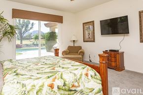 La Quinta house for rent - A bedroom with a large bed and a chair.