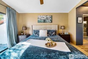 La Quinta house for rent - A bedroom with a large bed and a ceiling fan.