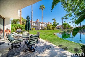La Quinta house for rent - A patio with a table and chairs overlooking a pool.