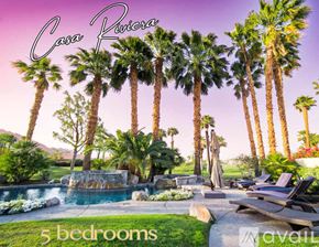 La Quinta house for rent - A pool surrounded by palm trees and a sign that says "Casa Riviera".