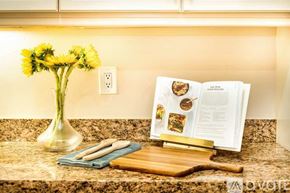 La Quinta house for rent - A kitchen counter with a vase of flowers, a cutting board, and an open cookbook.