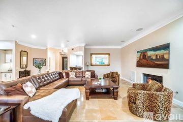 La Quinta house for rent - A living room with a brown leather couch and a fireplace.
