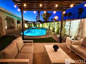 Indio house for rent - A pool surrounded by a patio with couches and a table.