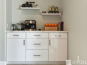 Indio house for rent - A kitchen with white cabinets and shelves holding various items.