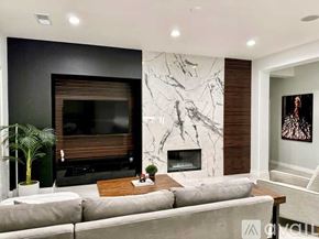 Indio house for rent - A modern living room with a grey sofa, a fireplace, and a TV.