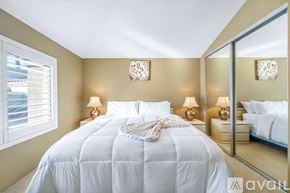 La Quinta house for rent - A bedroom with a large bed and a mirror on the wall.