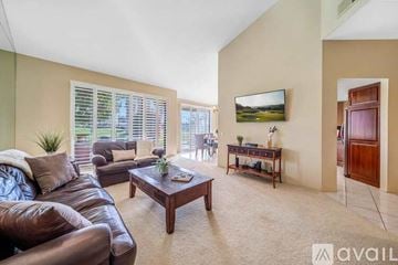 La Quinta house for rent - A living room with a brown leather couch and a wooden coffee table.