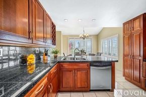 La Quinta house for rent - A kitchen with wooden cabinets and a black countertop.