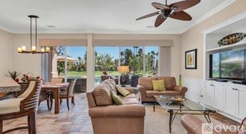 La Quinta house for rent - A living room with a brown couch and a ceiling fan.