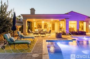 La Quinta house for rent - A house with a pool and lounge chairs in front.
